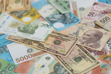 Big amount of money bills of different currencies and countries. Assortment background of international cash in big pile close up