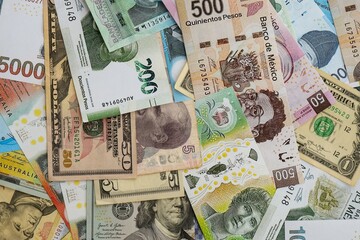 Big amount of money bills of different currencies and countries. Assortment background of international cash in big pile close up