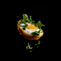 Egg with greens on dark backdrop