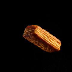 Flaky pastry on a black backdrop