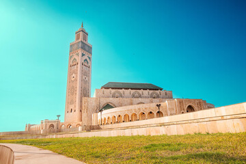 Hassan II Mosque dominating Casablanca's skyline under a vibrant blue sky, showcasing its intricate architecture and grandeur