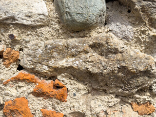 Ancient stone wall with fossilized shells and red brick fragments