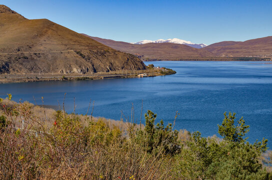 northern coast of Lake Sevan and snow-covered Bovakar mountain peaks scenic view from Sevanavank monastery (Gegharkunik Province, Armenia)