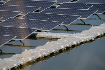 A row of solar panels are floating on a body of water. The panels are connected to each other and...