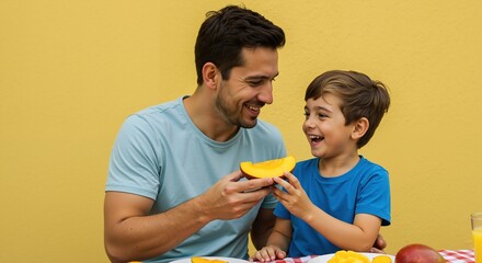 Caucasian father and son sharing yellow melon slice on yellow background. Man in light blue shirt feeding child fresh fruit. Family nutrition and healthy eating concept. Organic food sale