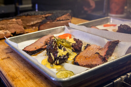 BBQ Brisket with beans collards pickles and a beer on a metal tray 
