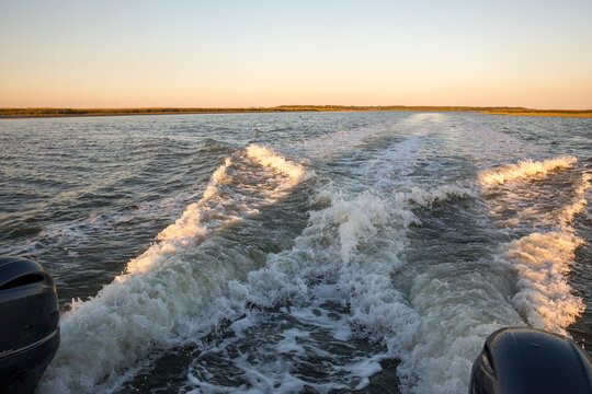 Back end view of a boat traveling in the water 