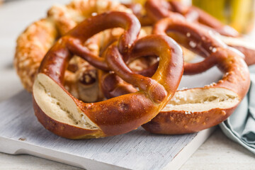 Salted bavarian pretzel on cutting board on kitchen table.