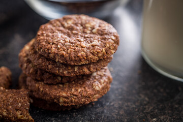 Sweet oatmeal cookies on black table.
