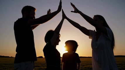 Silhouetted family creating a house shape with their hands against a stunning sunset, embodying themes of home, security, and the unity of love and togetherness - Powered by Adobe