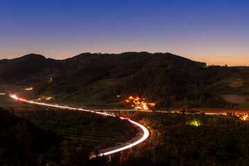Streets with little villages on the side, as seen at night from a vantage point. Scene in...
