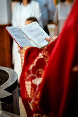 Priest Holding the Book of Needs During Religious Ceremony in Church