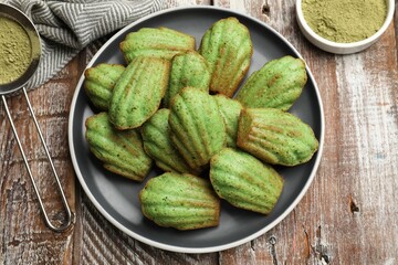 Tasty matcha madeleine cakes on wooden table, flat lay