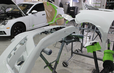 The bumper and rear fender removed from the car and painted in basic color in car paint shop