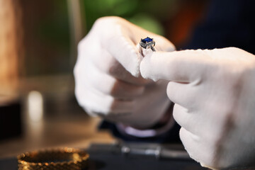 Appraiser working with luxury ring at table indoors, closeup. Space for text