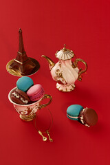 French macarons, teapot and eiffel tower on red background representing paris lifestyle