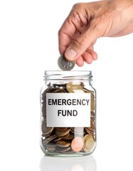 A mature hand carefully drops a coin into a clear glass jar labeled "Emergency Fund," symbolizing savings and financial security against a pristine white background.