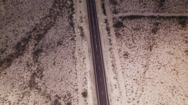 Aerial view of an empty stretch of desert highway near Big Bend in west Texas tilts up to horizon