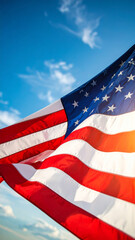 Obraz premium low angle view of stars and stripes on american flag against blue sky 