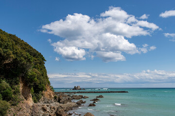 View along the rocky southern coastline of Ise-Shima National Park, Daiocho Funakoshi, Shima, Mie, Japan with cloudscape of large white cumulus clouds
