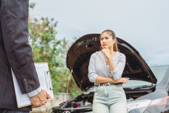 Asian woman customer and mechanic discussing car insurance. Female manager and car mechanic. Car repair and maintenance concept. - Powered by Adobe