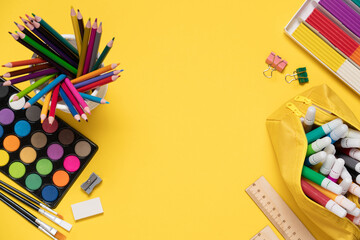 Bright stationery stuff, school supplies on yellow background top view. Back to school, creativity,...