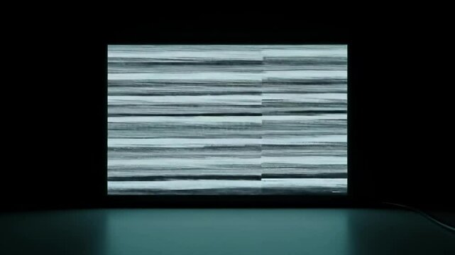 Glitchy screen with visual tearing in dark room displaying error patterns  