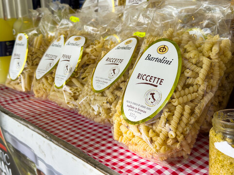 Italian pasta assortment on printed tablecloth in market display