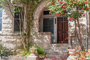 Facade of stone townhouse with front yard and landscaping.