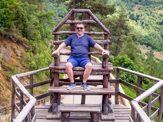 man enjoying himself on wooden chair