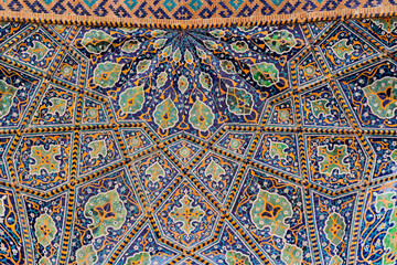 Vaulted ceiling with traditional uzbek geometric floral ornament on ceramic tile. Oriental intricate pattern mosaic. UNESCO World Heritage Site in Uzbekistan