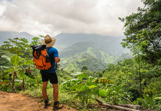 hiker in the mountains of sierra nevada of santa marta jungle in colombia with big backpack and hat - Powered by Adobe