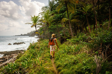 Male traveler walking in the tropical rainforest on the shores of the Caribbean Sea in Capurgana, Chocó, Colombia. Travel destination
