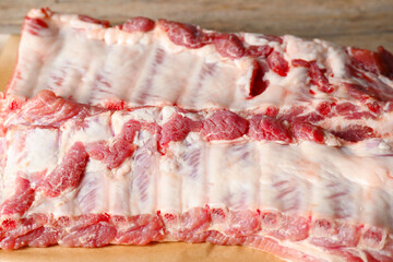 Raw pork ribs on wooden table, closeup