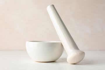 Ceramic mortar and pestle on white table, closeup