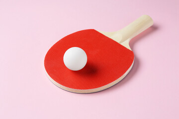 Ping pong racket and ball on pink background, closeup