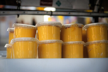 Traditional Brazilian sweet corn puddingserved in small cups at a street food stall or festival. 
