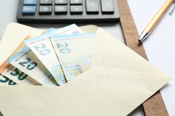 Money bonus. Envelope with euro banknotes on light grey background, closeup
