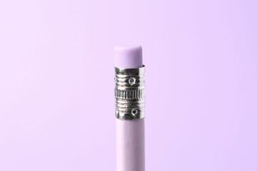 One graphite pencil with eraser on violet background, closeup