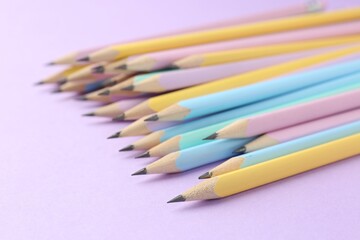 Many graphite pencils on violet background, closeup