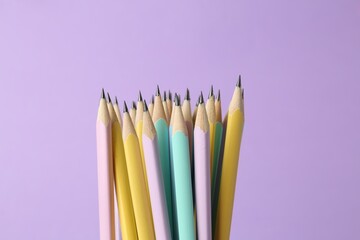 Many graphite pencils on violet background, closeup