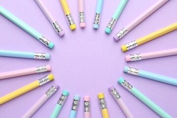 Frame made of many graphite pencils with erasers on violet background, flat lay. Space for text
