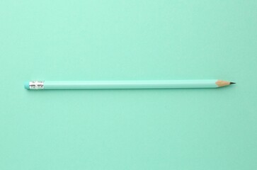 One graphite pencil with eraser on turquoise background, top view
