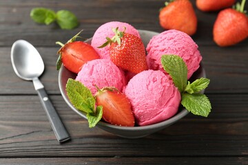 Tasty sorbet with strawberries and mint served on wooden table, closeup