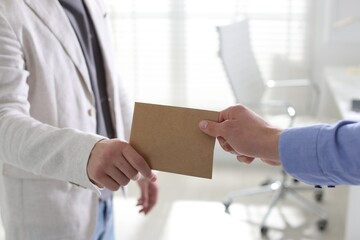 Money bonus. Employee receiving envelope from boss in office, closeup