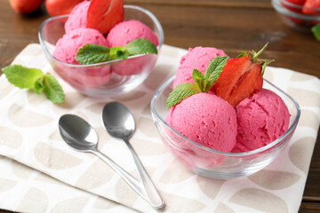 Tasty sorbet with strawberries and mint served on wooden table, closeup