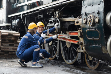 Locomotive repair garage, Mechanic, Engine Mechanic. Engineer checking, repairing, maintaining locomotive engine. Railway engineer and train wheel in train garage