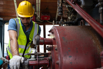 Locomotive repair garage, Mechanic, Engine Mechanic. Engineer checking, repairing, maintaining locomotive engine. Railway engineer and train wheel in train garage