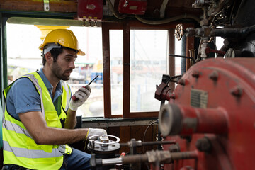 Locomotive repair garage, Mechanic, Engine Mechanic. Engineer checking, repairing, maintaining locomotive engine. Railway engineer and train wheel in train garage