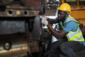 Locomotive repair garage, Mechanic, Engine Mechanic. Black people. African American engineer checking, repairing, maintaining locomotive engine. Railway engineer and train wheel in train garage